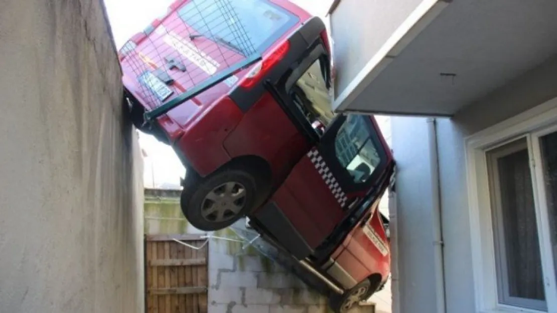 Freni boşalan dolmuş taksi, bina boşluğunda asılı kaldı