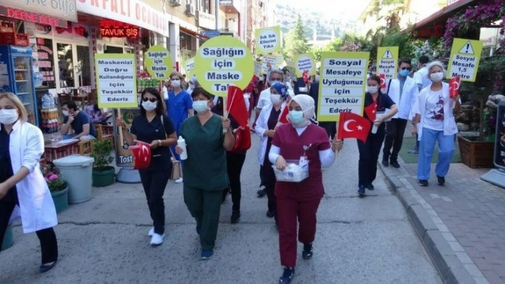 Sağlık çalışanları, maske ve sosyal mesafeye dikkat çekmek için yürüdü