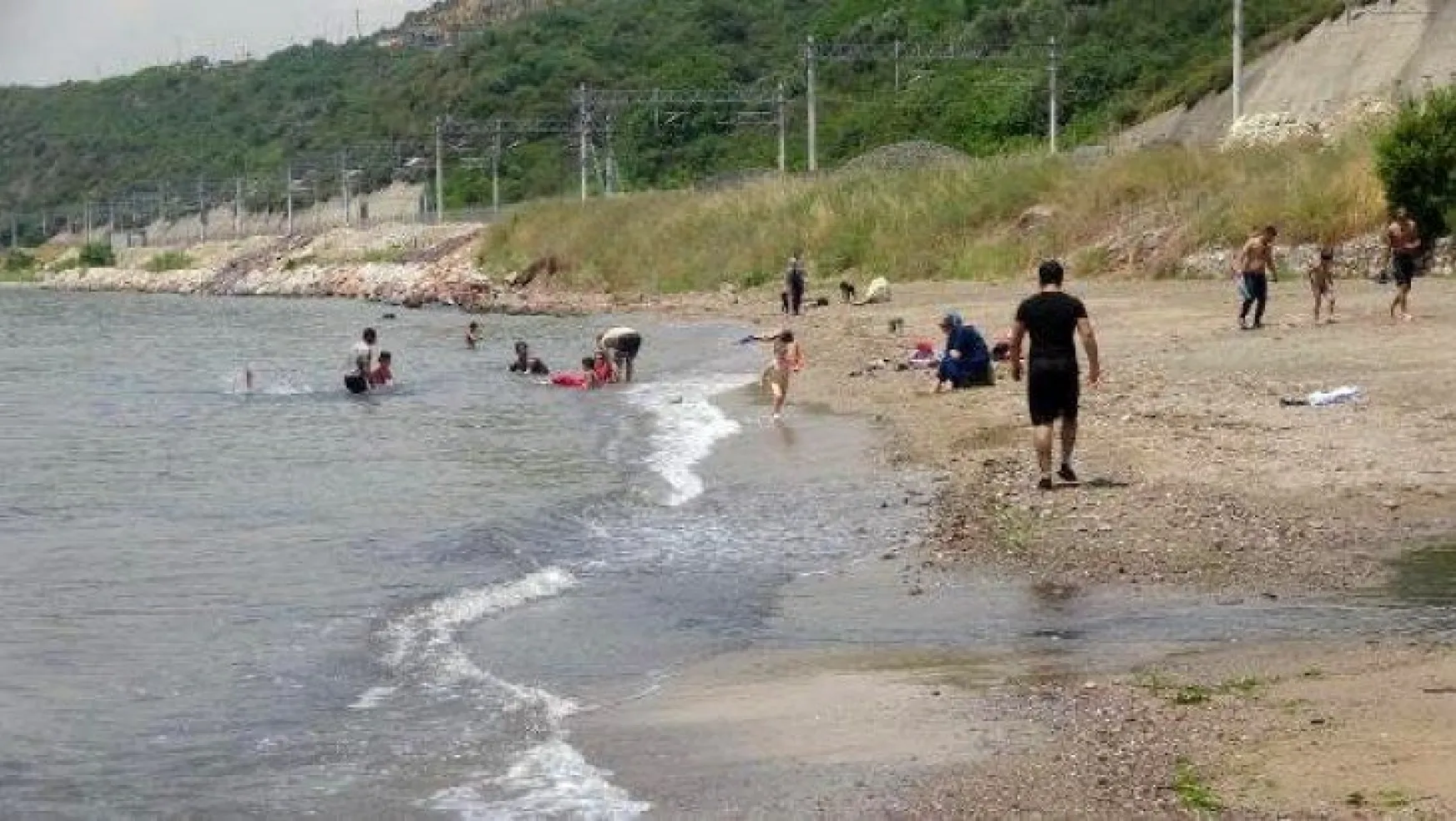 Simsiyah akan derenin kirlettiği plajda, denize girdiler