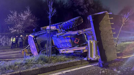 Bariyere çarpan iş makinesi refüje devrildi: 2 yaralı