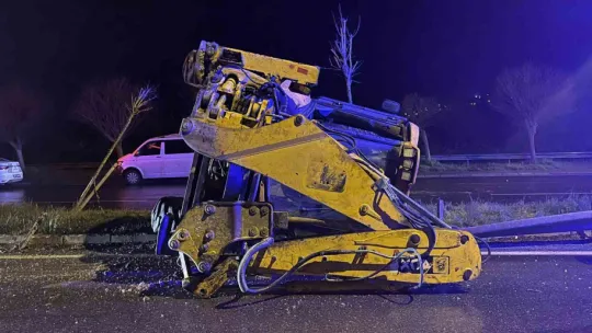 Bariyere çarpan iş makinesi refüje devrildi: 2 yaralı