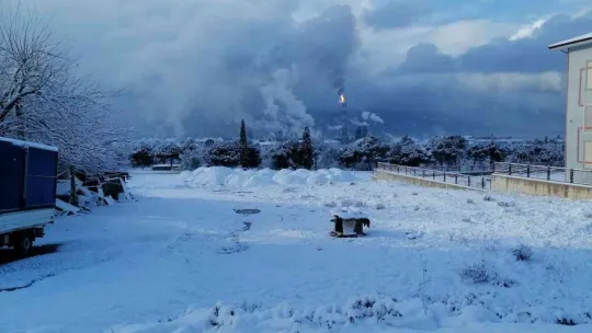 Bembeyaz kar yağışı altında, simsiyah TÜPRAŞ dumanı