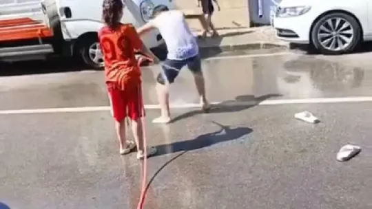 Çocuklar akaryakıt istasyonundaki köpükle serinledi