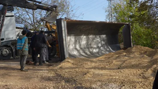 Mıcır yüklü kamyonun damperi devrildi, sürücü bayıldı