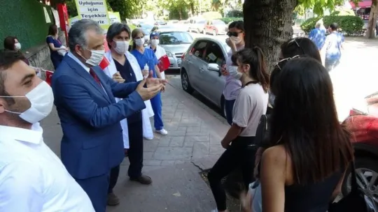 Sağlık çalışanları, maske ve sosyal mesafeye dikkat çekmek için yürüdü