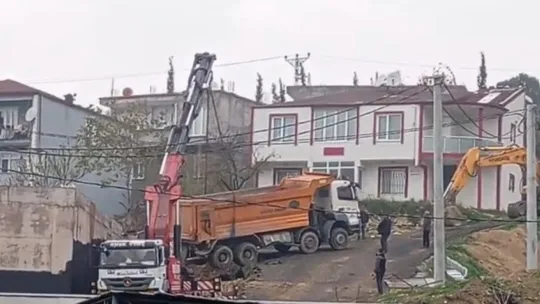 Yük boşaltan kamyon askıda kaldı