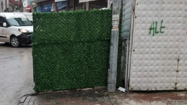 Kaldırım girişinde çöp konteyneri 