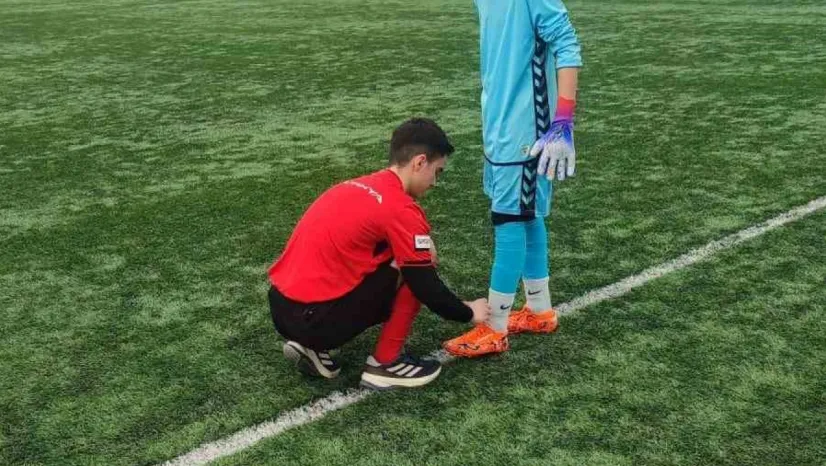 Hakem futbolcunun kramponlarını bağladı